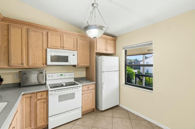 kitchen with light tile patterned floors, light countertops, white appliances, and baseboards