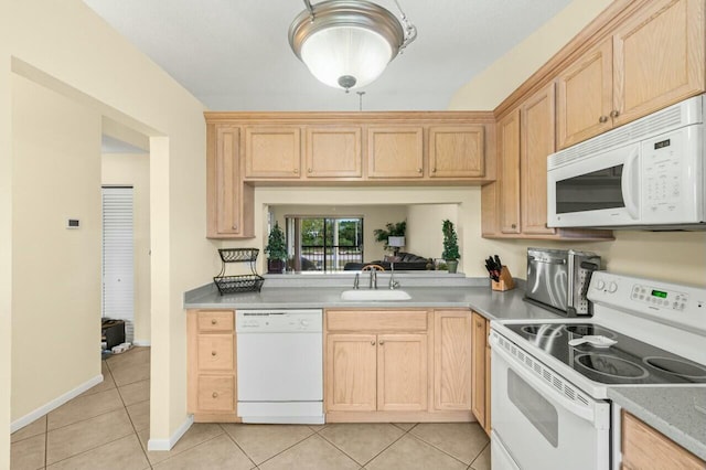 kitchen with white appliances, light countertops, a sink, and light tile patterned flooring