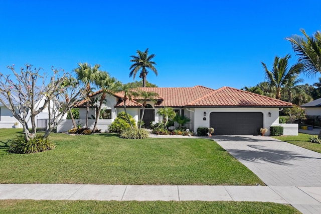 mediterranean / spanish house featuring a garage and a front yard