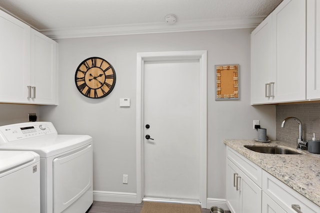 washroom featuring cabinets, washing machine and clothes dryer, crown molding, and sink