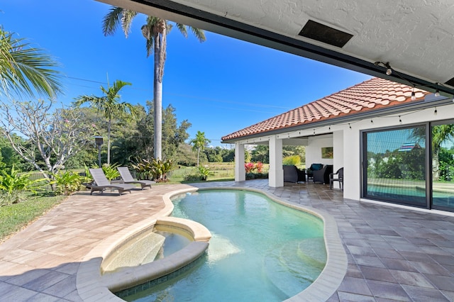 view of swimming pool with an in ground hot tub and a patio