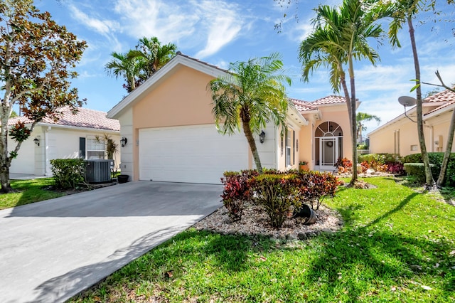 mediterranean / spanish home featuring a garage, cooling unit, and a front yard