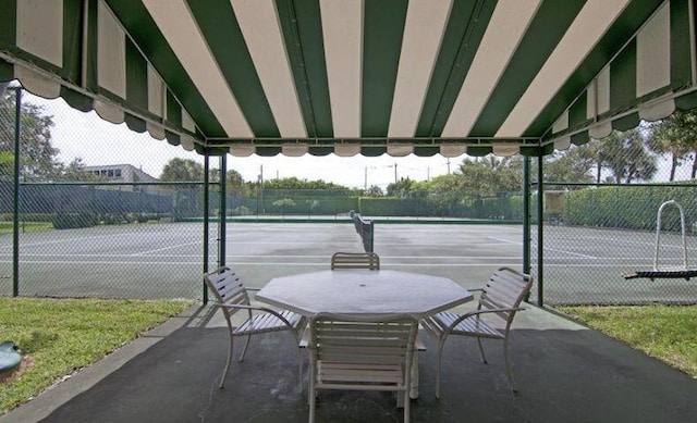 view of tennis court featuring fence