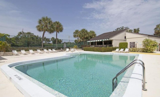 pool featuring fence and a patio