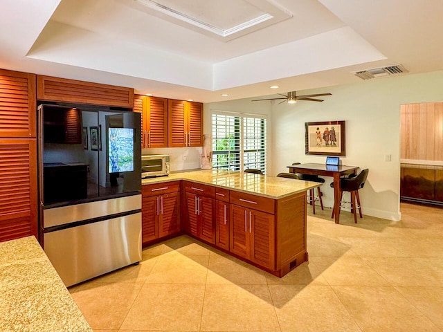 11373 Twelve Oaks Way E, North Palm Beach, FL 33408 - kitchen with smart refrigerator, a tray ceiling, a peninsula, light tile patterned floors, and recessed lighting
