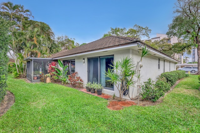 11373 Twelve Oaks Way E, North Palm Beach, FL 33408 - back of property featuring stucco siding, a sunroom, and a lawn