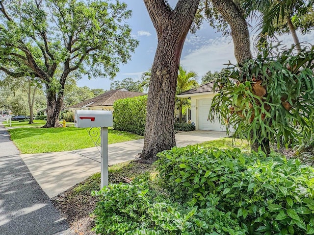 11373 Twelve Oaks Way E, North Palm Beach, FL 33408 - view of front of home with stucco siding, a front lawn, concrete driveway, and a garage