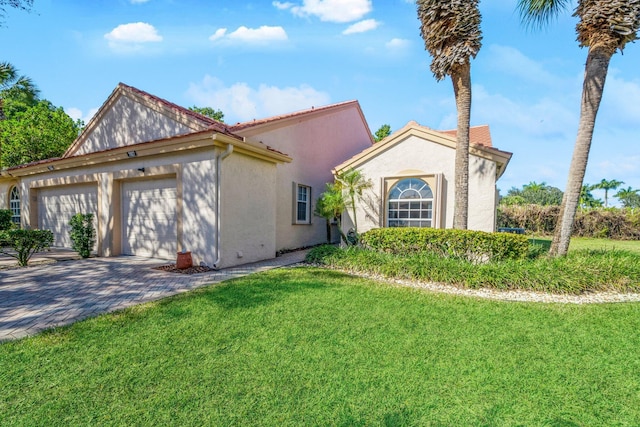 mediterranean / spanish-style home featuring a garage and a front lawn