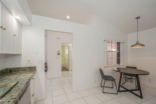 tiled dining area featuring vaulted ceiling