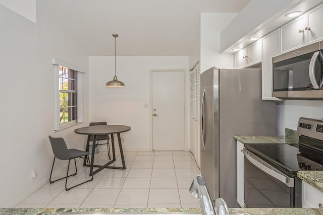 kitchen featuring stainless steel appliances, white cabinetry, hanging light fixtures, and light stone countertops