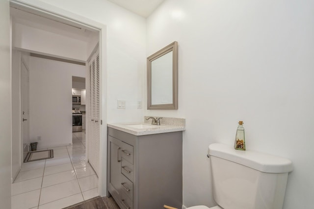 bathroom with vanity, tile patterned floors, and toilet