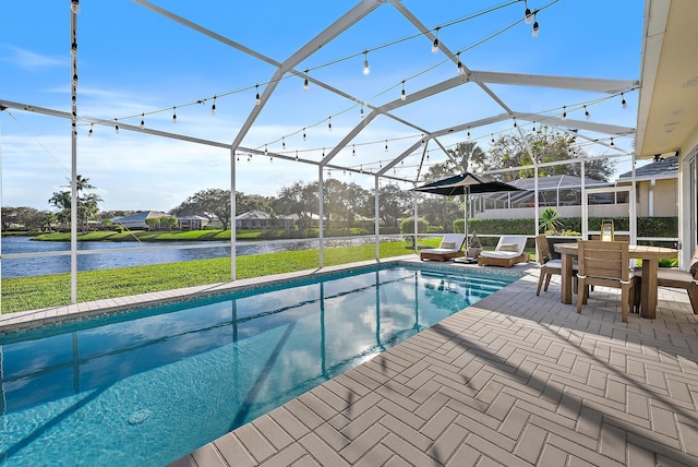 view of swimming pool featuring a patio, a water view, a yard, and a lanai