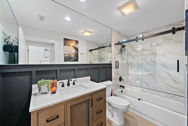 full bathroom with shower / bath combination with glass door, vanity, toilet, and hardwood / wood-style floors