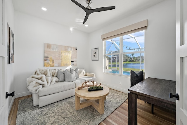 living room featuring a water view, ceiling fan, and hardwood / wood-style floors