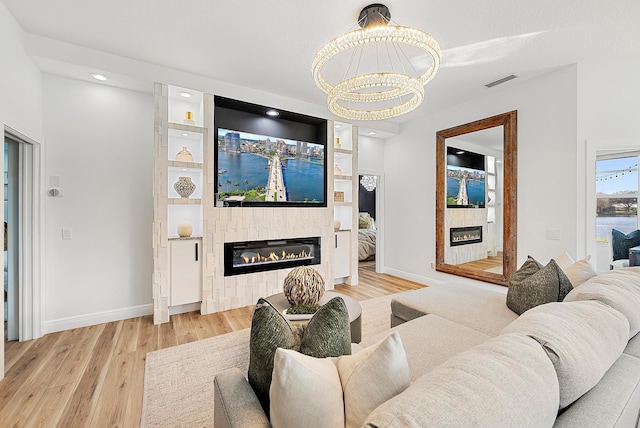 living room with an inviting chandelier and light hardwood / wood-style floors