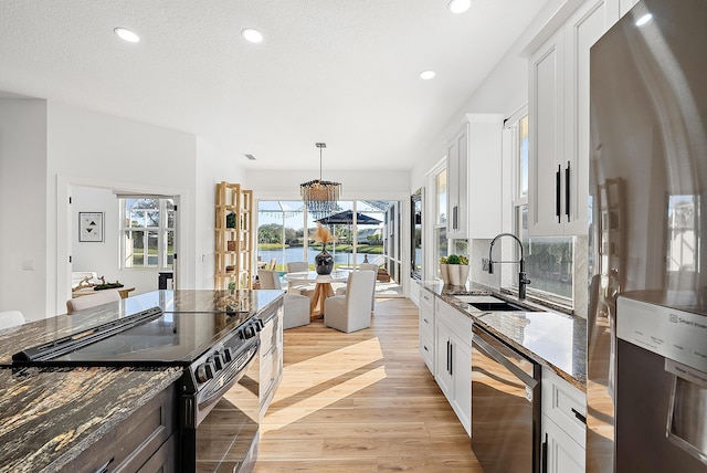 kitchen featuring white cabinetry, black electric range, dishwashing machine, and stainless steel fridge with ice dispenser