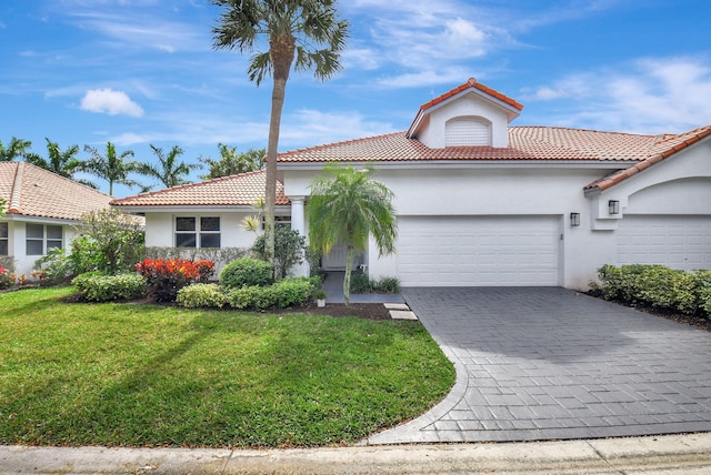 mediterranean / spanish house with a garage and a front yard