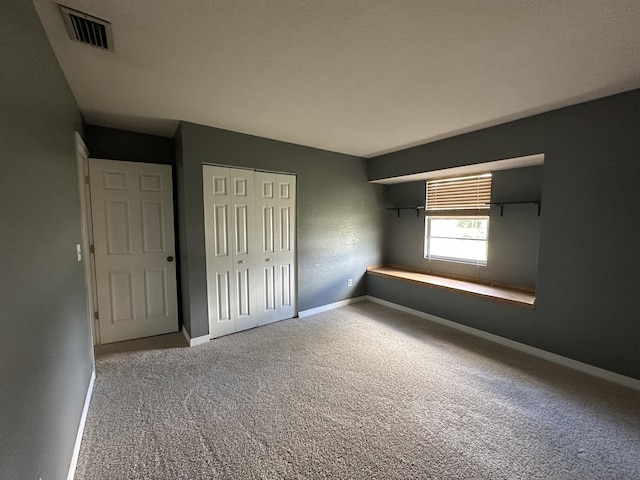 unfurnished bedroom featuring carpet floors and a closet