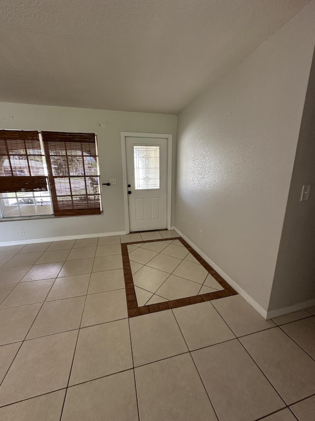 doorway to outside with light tile patterned floors