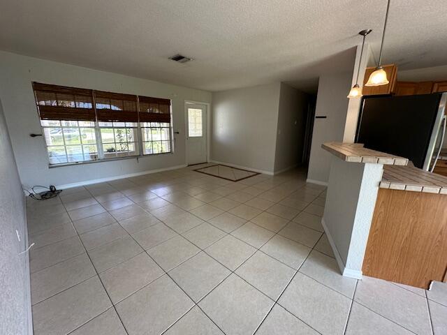 interior space featuring a textured ceiling and light tile patterned floors