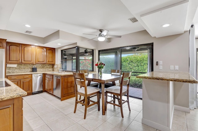 kitchen with tasteful backsplash, light stone counters, kitchen peninsula, and dishwasher