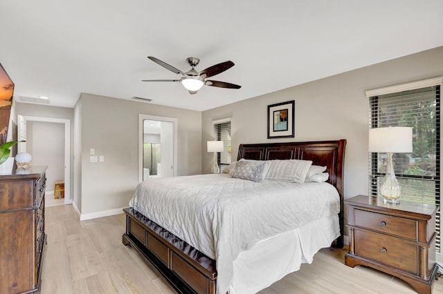 bedroom with ensuite bathroom, ceiling fan, and light wood-type flooring