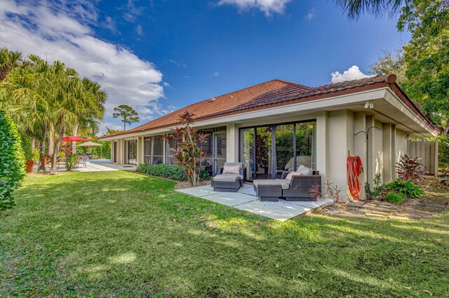 back of property with an outdoor living space, a yard, and a patio area