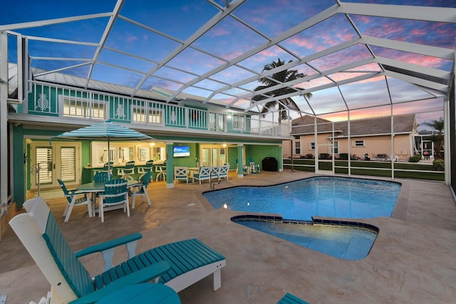 2666 SE Erickson Dr, Port Saint Lucie, FL 34984 - pool at dusk with a patio area and glass enclosure