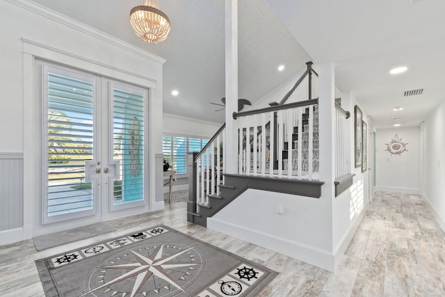 2666 SE Erickson Dr, Port Saint Lucie, FL 34984 - stairway featuring hardwood / wood-style floors, crown molding, french doors, and a chandelier