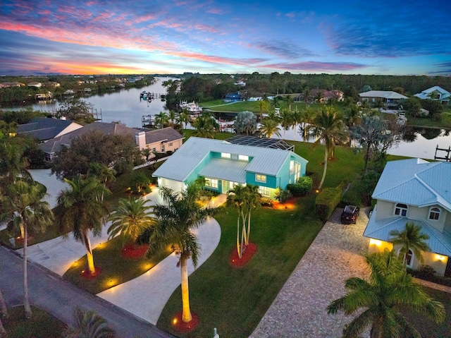 aerial view at dusk featuring a water view