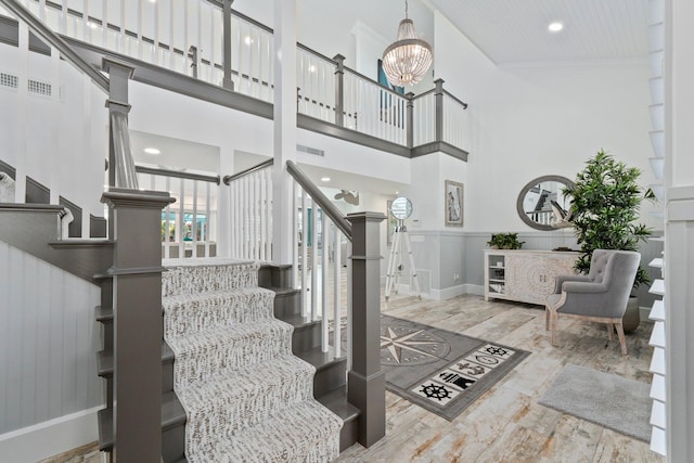 2666 SE Erickson Dr, Port Saint Lucie, FL 34984 - stairs with hardwood / wood-style flooring, a chandelier, and a high ceiling