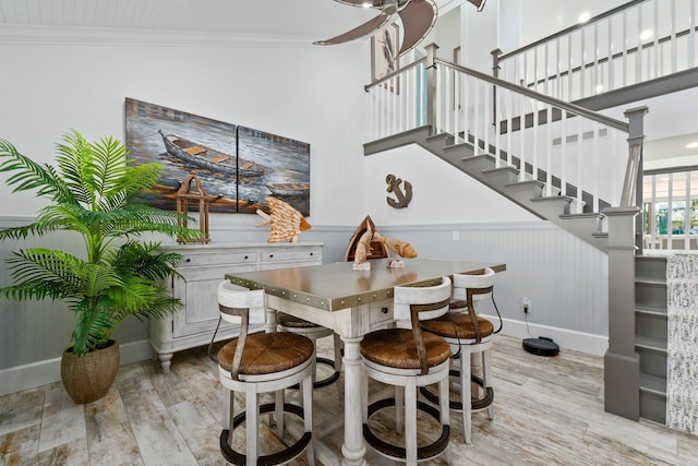 2666 SE Erickson Dr, Port Saint Lucie, FL 34984 - dining space with light hardwood / wood-style flooring, ornamental molding, ceiling fan, and a high ceiling