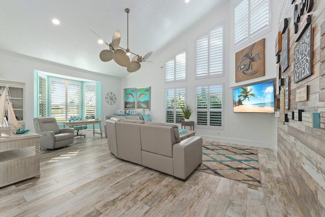 2666 SE Erickson Dr, Port Saint Lucie, FL 34984 - living room featuring ceiling fan, high vaulted ceiling, and light wood-type flooring