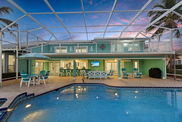 2666 SE Erickson Dr, Port Saint Lucie, FL 34984 - back house at dusk with a lanai and a patio area