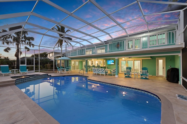 2666 SE Erickson Dr, Port Saint Lucie, FL 34984 - pool at dusk featuring a lanai and a patio area
