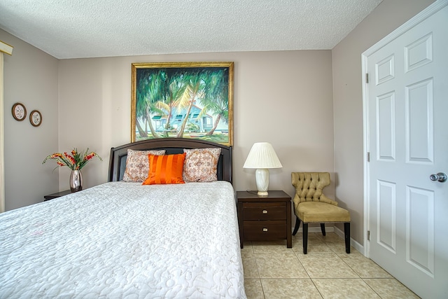 bedroom featuring light tile patterned floors and a textured ceiling