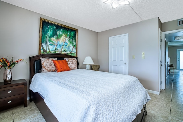 bedroom with a textured ceiling and light tile patterned floors