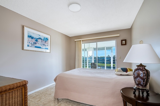 tiled bedroom with access to exterior and a textured ceiling