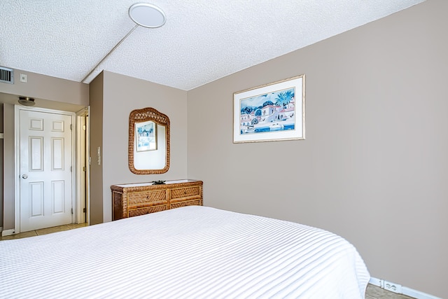 bedroom featuring tile patterned floors and a textured ceiling