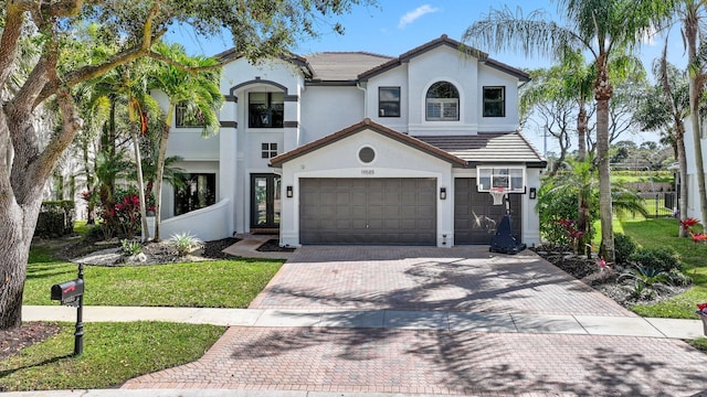 mediterranean / spanish house featuring a garage and a front lawn