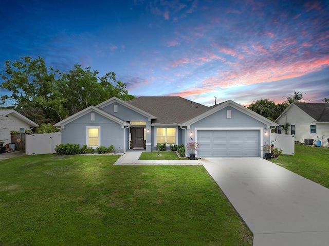 ranch-style house with central AC, a garage, and a lawn