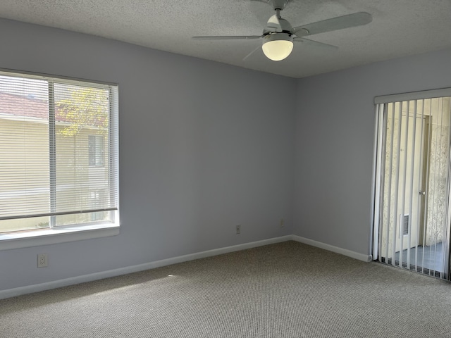 empty room with carpet flooring, plenty of natural light, a textured ceiling, and ceiling fan