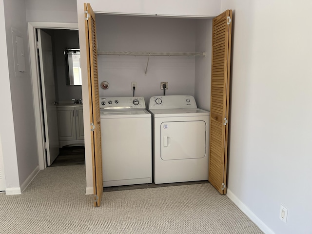 washroom featuring light carpet, laundry area, washing machine and dryer, and baseboards