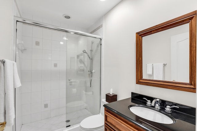 bathroom with vanity, a shower with shower door, and toilet