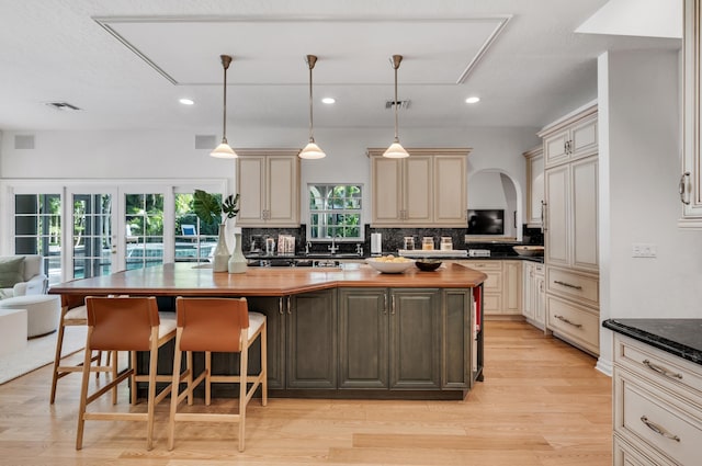 kitchen featuring wooden counters, a breakfast bar area, cream cabinets, and a kitchen island