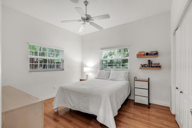 bedroom with hardwood / wood-style flooring, ceiling fan, and a closet