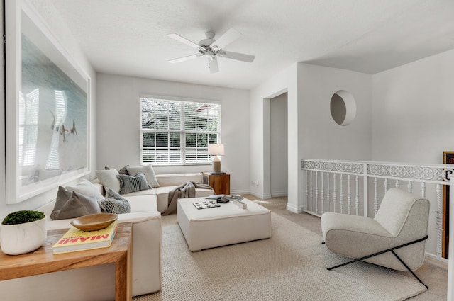 living room featuring a textured ceiling, light colored carpet, and ceiling fan