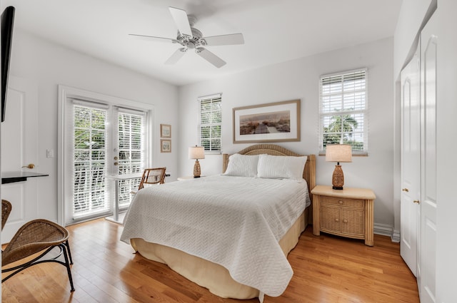 bedroom featuring ceiling fan, multiple windows, access to exterior, and light hardwood / wood-style flooring