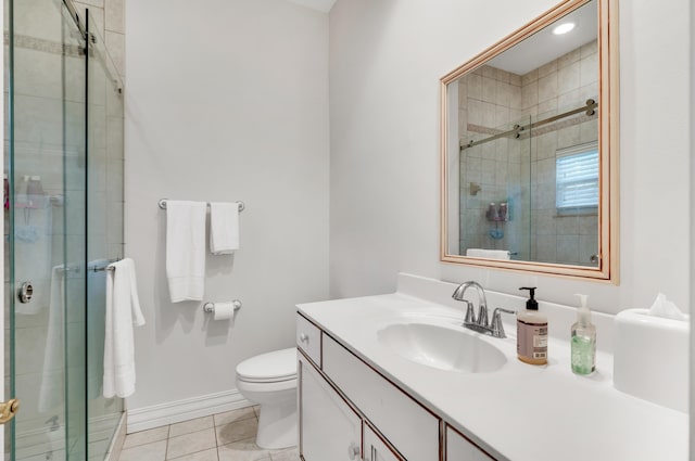 bathroom featuring tile patterned flooring, toilet, vanity, and walk in shower