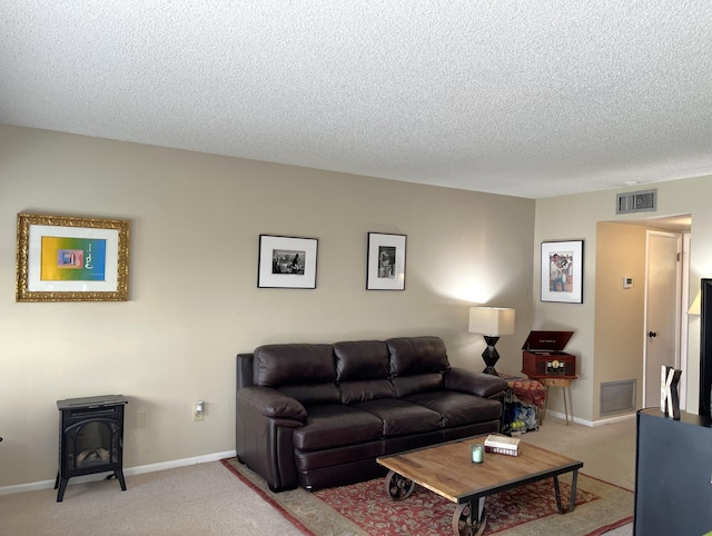 living room with carpet, a textured ceiling, and a wood stove